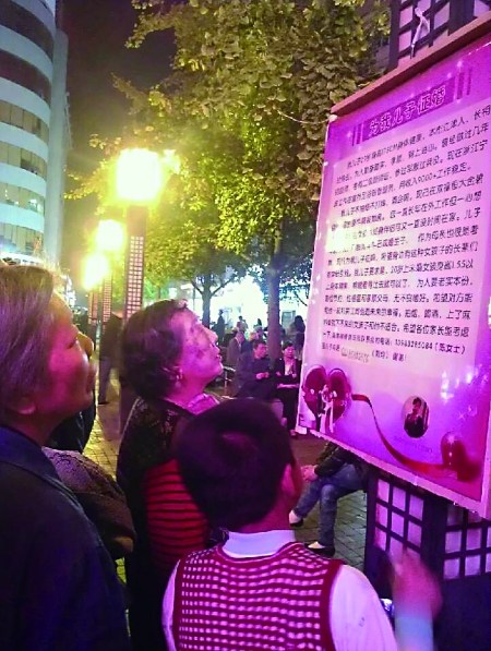 儿子外地打工忙母亲闹市举广告牌帮忙征婚