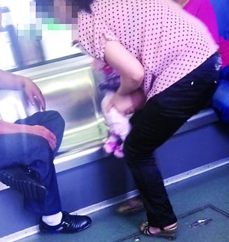 网曝重庆轻轨上女子抱孩子便溺周围还有其他小孩
