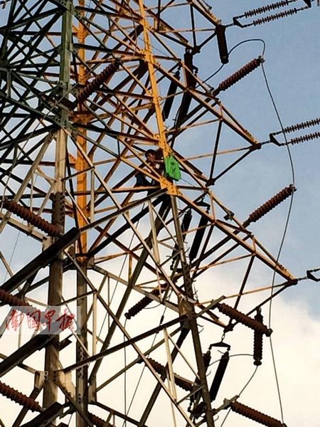 男子爬铁塔扬言自杀却还淡定玩自拍报料(图)