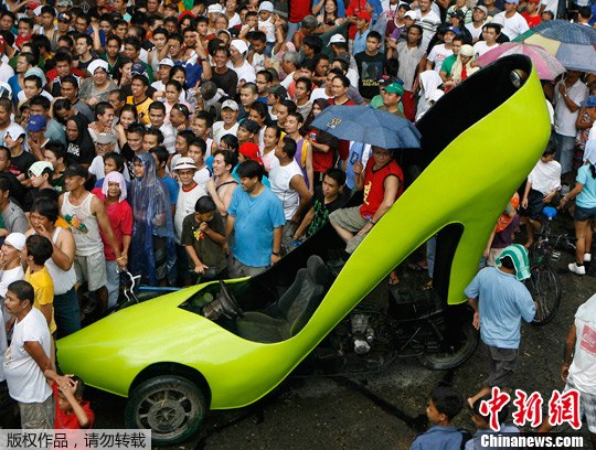 众多民众观看一场拳击赛,一名男子乘着一辆荧光绿色高跟鞋造型的车