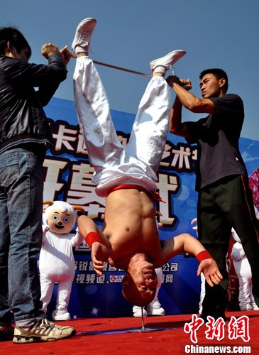 12月4日,被誉为"中国倒立王"的民间艺人李鑫在广西南宁动物园表演高