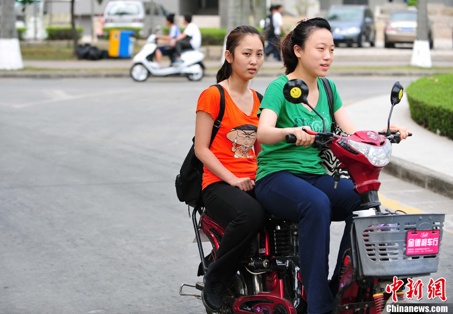 女大学生骑电车靓丽身影增添校园春意