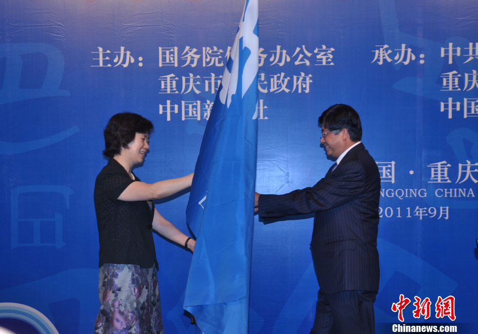 图为中共重庆市委副书记张轩(左)向青岛市副市长秦敏(右)移交论坛会旗