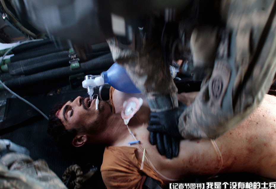 军医在医疗直升机上给一名伤势严重但身份不明的阿富汗国民军士兵做心