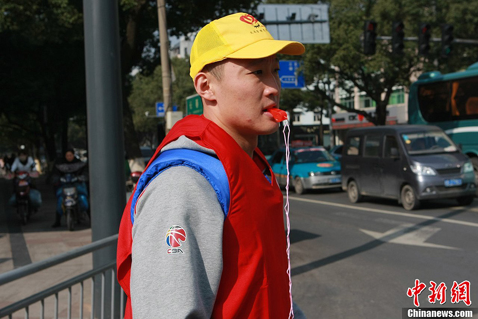 八一富邦队队员王中光口吹哨子指挥交通