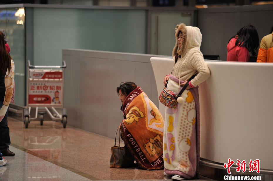 昆明机场航班延误 滞留旅客身披毛毯御寒