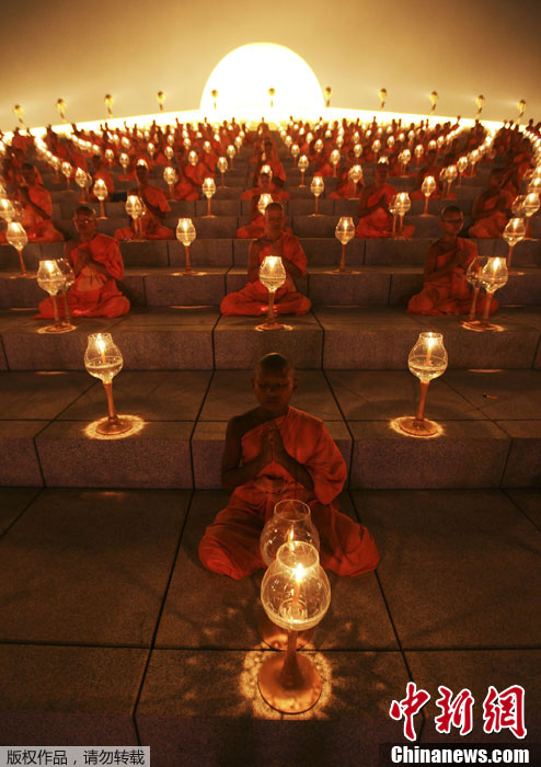 当地时间2月25日,泰国巴吞他尼府,僧侣在法身寺燃烛诵经,进行祈祷