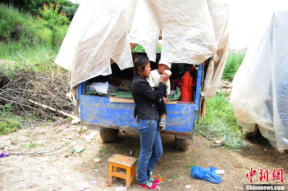 甘肃定西地震：农用“帐篷车”前的母女情