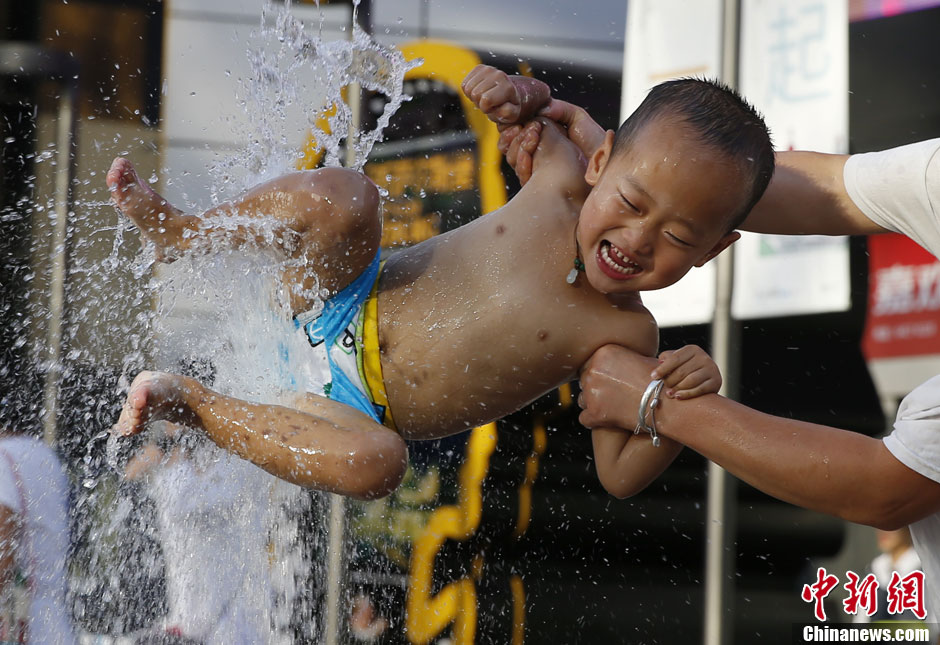北京发布高温橙色预警 三里屯喷泉成孩童“避暑乐园”