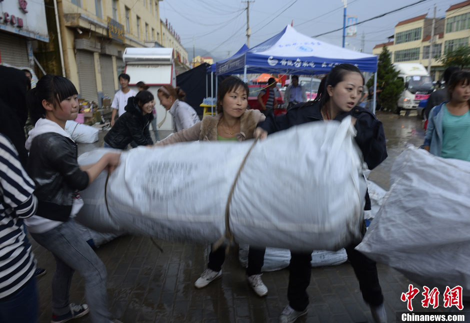 甘肃岷县漳县地震：美女志愿者冒雨分发帐篷