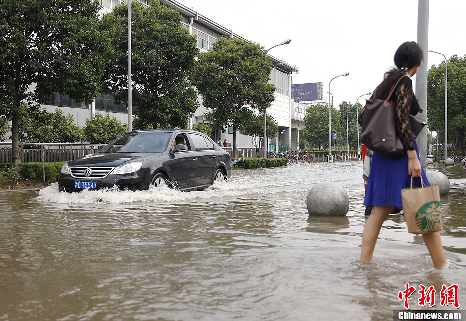 上海暴雨致地铁口积水市民涉水前行