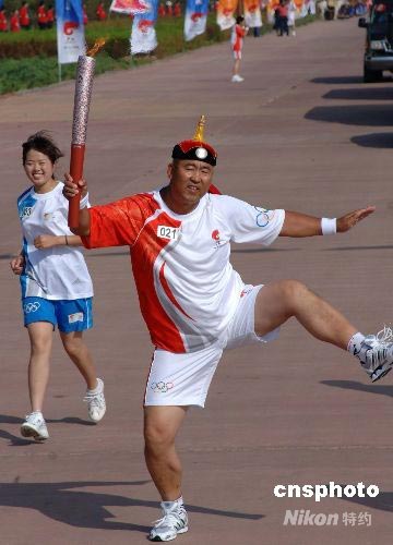 图鄂尔多斯火炬手摔跤动作传递奥运火炬