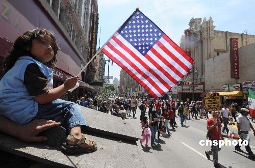 图为一名小女孩在街边挥舞星条旗为游行队伍加油.中新社发 张炜 摄