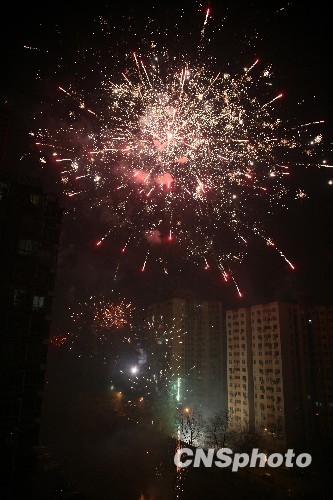 图为除夕夜北京西郊一社区鞭炮齐鸣,烟花灿烂.中新社发 孙自法 摄