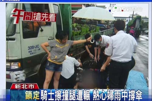 骑士遇车祸腿被车压住热心妇人雨中撑伞守护(图)