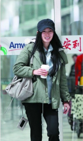 杨幂戴黑帽素颜回京穿军绿色大衣与助理说笑(图)