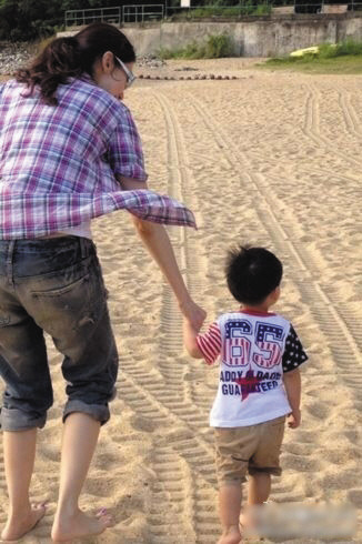李嘉欣晒母子照2人牵手沙滩漫步爱子露白胖小腿